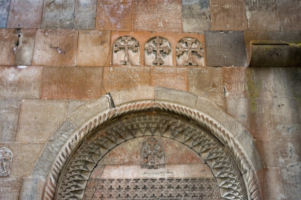 Detailed stone carving with crosses and carvings on an old church wall, Khor Wirap monastery, deep
