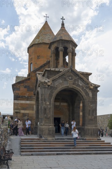 Church building with decorative entrance and dome, people enter the historic building, Khor Virap
