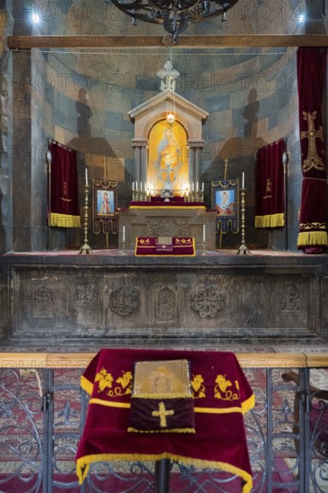 The altar with a variety of religious symbols and candles on decorated textiles, Khor Virap