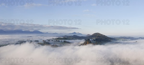 View of wooded hills emerging from foggy morning light, near Roßhaupten, Ostallgäu, Allgäu, Swabia,