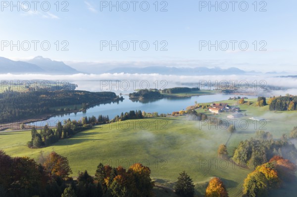A picturesque view of Lake Forggensee surrounded by autumn landscape, near Roßhaupten, Ostallgäu,