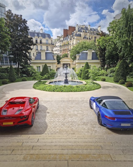 Two luxury sports cars parked in the driveway of an opulent Parisian mansion with view to a