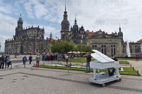 Dresden, Gerrmany- May 6, 2017: Musicians are playing on the sqare in the background Cathedral of