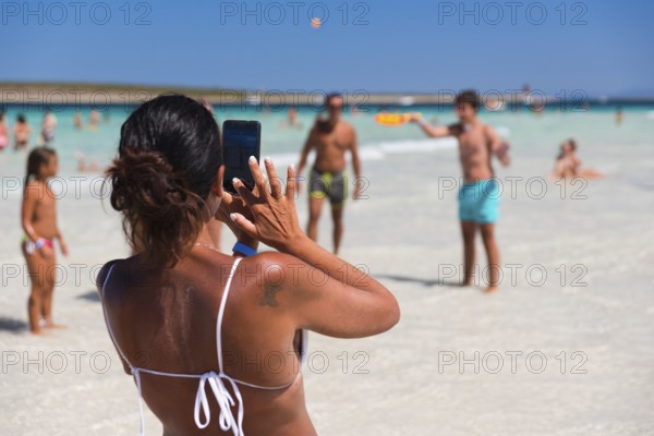 STINTINO, ITALY - AUGUST 21, 2017 - Unidentified woman take picture people on the famous La Pelosa