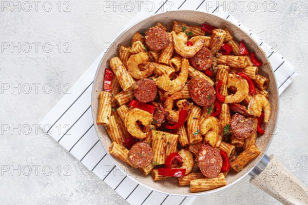 Jambalaya pasta with shrimp and sausages, cooked with bell pepper in a frying pan, homemade, on a