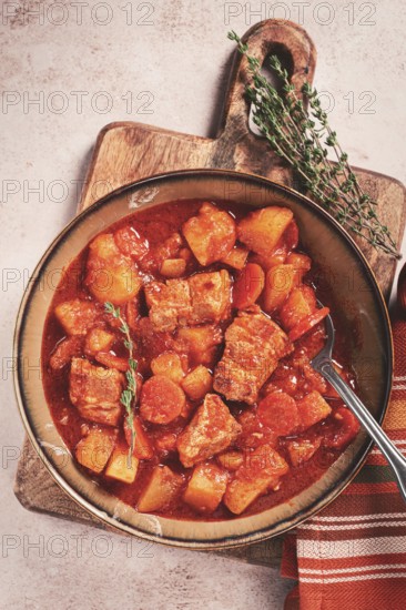 Meat goulash with potatoes and carrots, sweet peppers, in a saucepan, top view, traditional