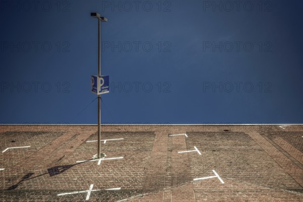 The frog-eye view transforms a paved parking lot in Cologne into a steep wall against a deep blue