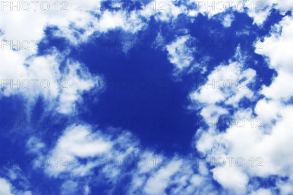 Blue spring sky with snow-white clouds of bizarre shapes. Increased cloudiness with changeable