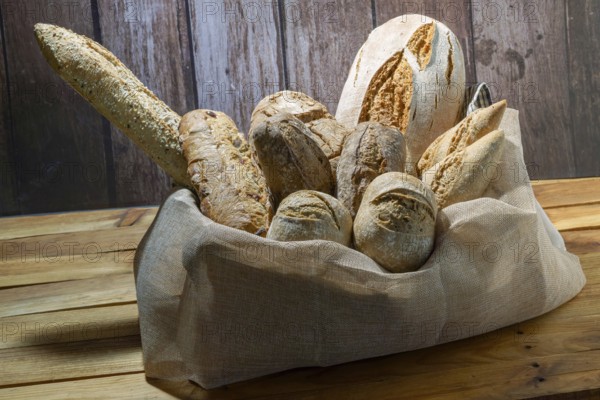 Freshly baked artisanal bread assortment including baguettes and rolls, creating a rustic still