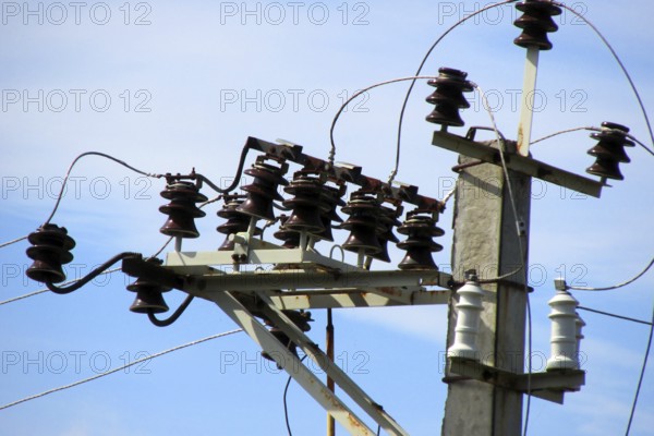 Electrical cables and ceramic, porcelain insulators of high voltage transmission line on top of