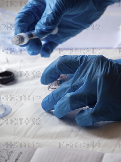 Stambul, Turkey October 21st 2025 Hands in blue gloves preparing a syringe and medication for