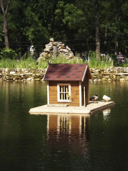 Pond with bird house on the backdrop of an alphine slide in Gorky Park. One of the well-known