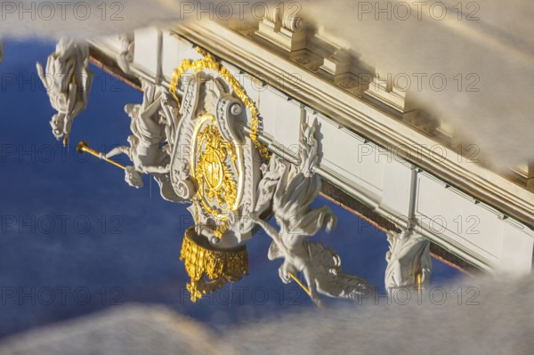 Angel statues on the roof of the Hofburg Imperial Palace are reflected in a waterhole, Vienna,