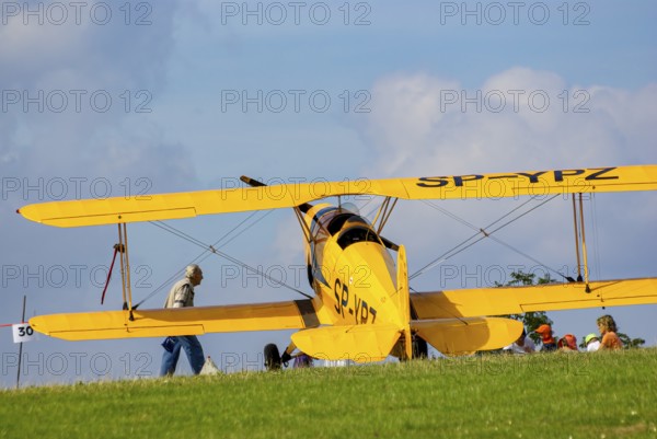 A Bücker Bü 131 Jungmann biplane parked at the edge of the airfield, SP-YPZ registration, as part