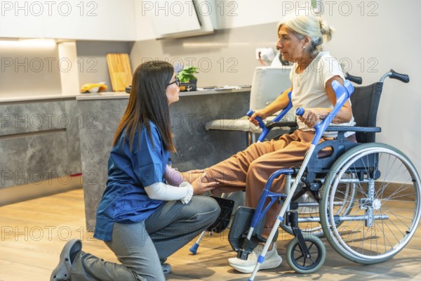 Nurse assisting an elderly woman in a wheelchair with home physiotherapy, providing gentle physical