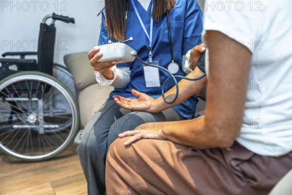 Healthcare professional checking a person's blood pressure with a cuff and digital monitor,