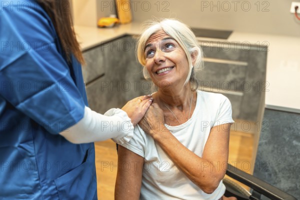 Healthcare professional in scrubs placing a comforting hand on the shoulder of a smiling senior