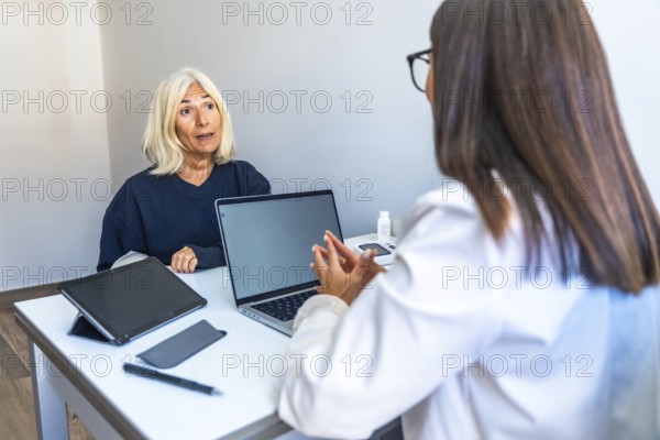 Senior woman is talking with a female doctor during a medical consultation in a modern office,