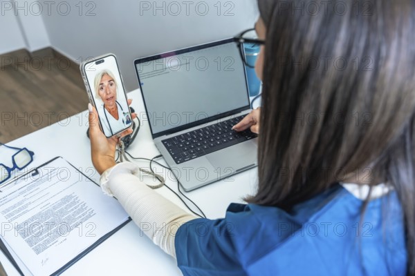 Healthcare professional having a video conference with a doctor on a smartphone while using a