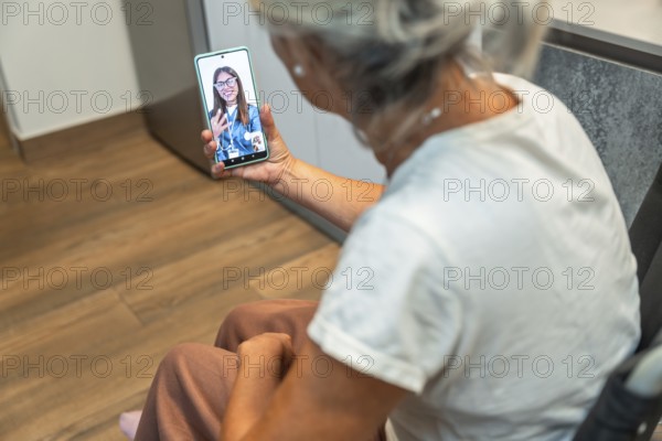 Senior woman using her mobile phone for a video consultation with a female doctor, accessing