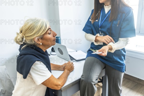 Doctor in scrubs explaining a new prescription to an attentive senior patient during a medical