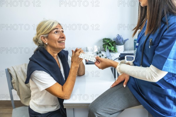 Medical professional giving a blister pack of pills to an elderly woman during a consultation,