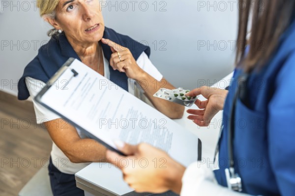 Medical professional discussing treatment options and handing blister pack of pills to an elderly