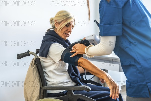 Medical professional monitoring the vital signs of an elderly patient with a blood pressure cuff