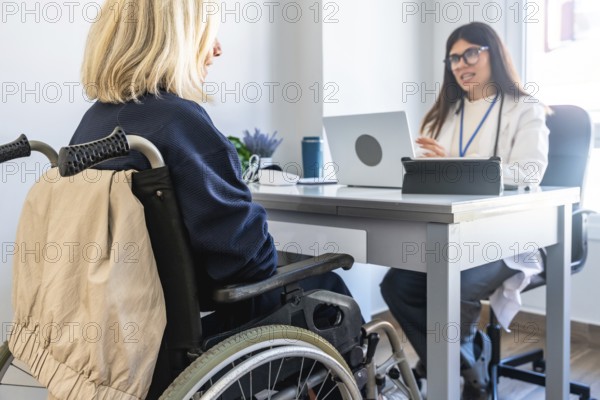 Patient in a wheelchair receiving medical advice from a female doctor during a healthcare