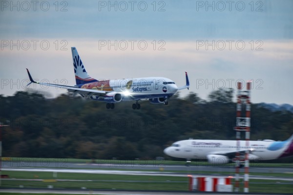 Sunexpress Boeing 737 landing at Düsseldorf airport, Eurowings aircraft waiting for takeoff, North