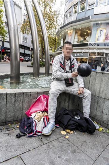 Man in public consumes laughing gas filled into a balloon with a gas cartridge, still legal
