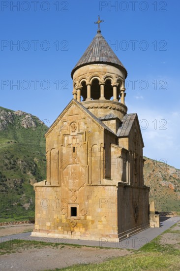 A church with ornate stone architecture against a clear blue sky, Noravank monastery, Surb
