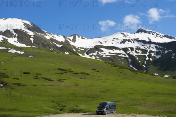Snow and grassy hills stretch under a cloudy blue sky, Camper, Zagari Pass, Svaneti, Svaneti,