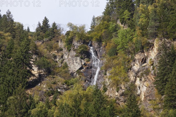 Waterfall with forest and mountains on Wilde Wasser Weg in autumn, WildeWasserweg, Stubai Valley,