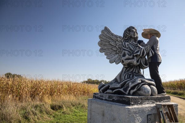 Chandler, Minnesota - Artist Primi Monteiga re-paints her concrete sculpture of an angel in the