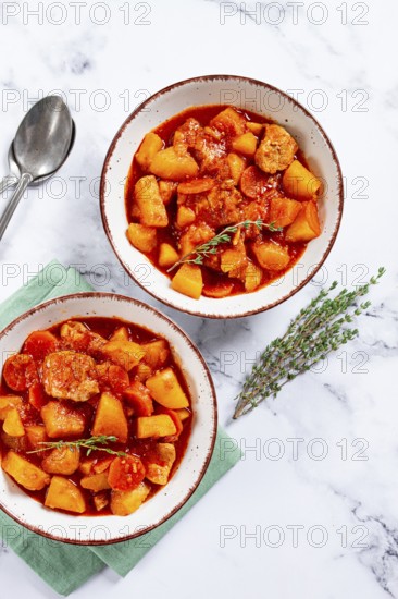 Meat goulash with potatoes and carrots, sweet peppers, in a saucepan, top view, traditional