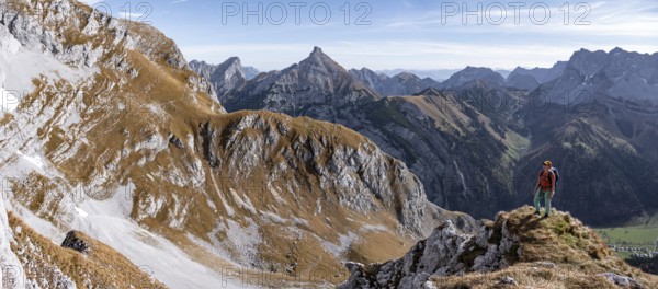 Female hiker standing on a rock and looking into the valley, hiking to Gamsjoch, down the