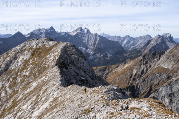 Hikers on the Gamsjoch ridge with a view of the vast mountain landscape, behind Dreizinkenspitze