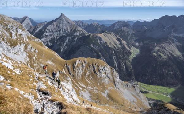Hiker on a rocky mountain trail with a wide view of the valley, eastern Karwendel, Tyrol, Austria