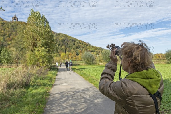 Woman photographing Kaiser Wilhelm monument, mountain, forest, path, Porta Westfalica, North