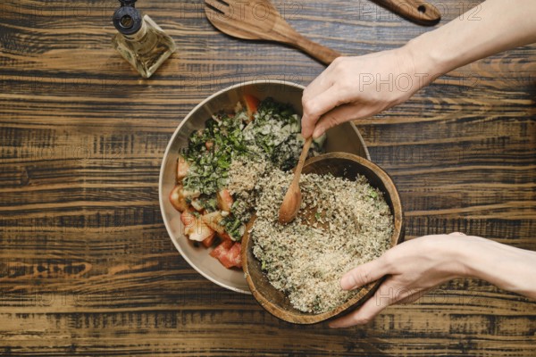 Adding ground walnuts to a bowl with chopped vegetables and herbs. A wooden spoon is used to