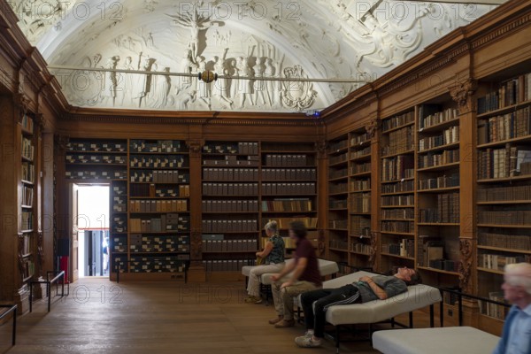 Visitors looking at 17th century stucco on library ceiling of the Park Abbey, Premonstratensian