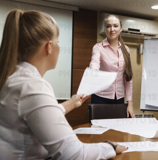 Business meeting at company office. Several men and women in suits discussing working problems