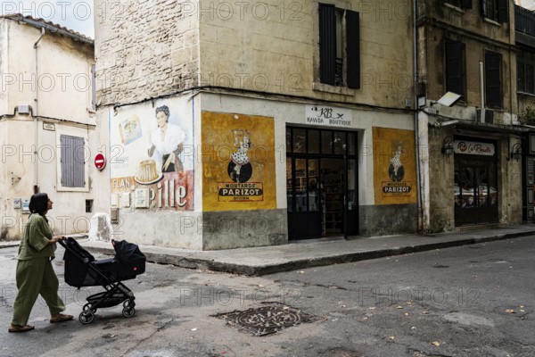 Woman with stroller, wall painting, advertisement, 1950s, corner house with old advertisement,