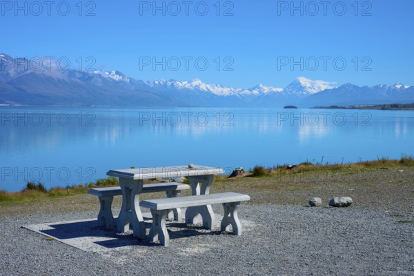 A lakeside picnic table with views of snow-capped mountains and calm water, Lake Pukaki Viewpoint,