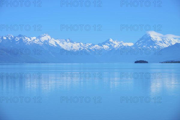 Calm lake with snow-capped mountains Mount Cook and a small island in the background, Lake Pukaki
