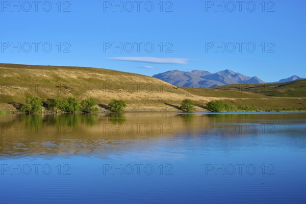 Blue sky over a calm lake with mountains in the background, Lake McGregor, Tekapo, Canterbury,