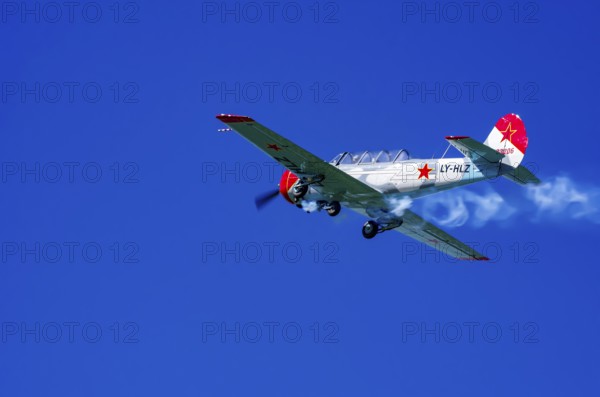 A Jakovlev Jak-52 with registration LY-HLZ during a flight demonstration as part of an air show on
