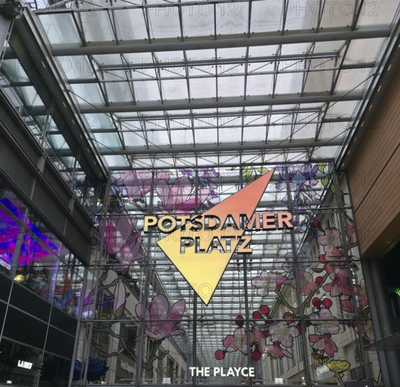 Colourful glass façade with lettering in the covered atrium on Potsdamer Platz, floral patterns and