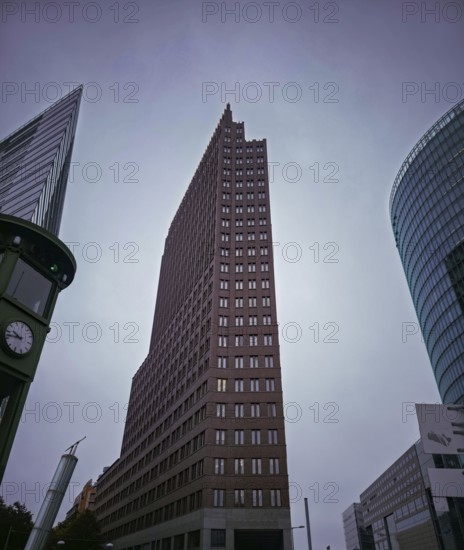 Dramatic upward view of modern skyscrapers on Potsdamer Platz under grey skies, at Potsdamer Platz